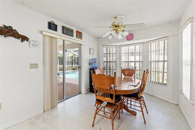 a view of a dining room with furniture a chandelier and a window