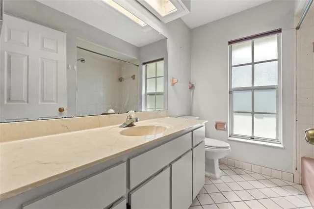 a bathroom with a sink a toilet and a window