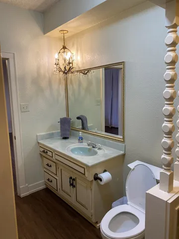 a bathroom with a granite countertop toilet sink and mirror