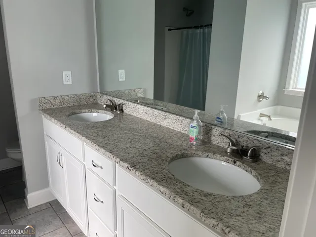 a bathroom with a granite countertop sink and a mirror
