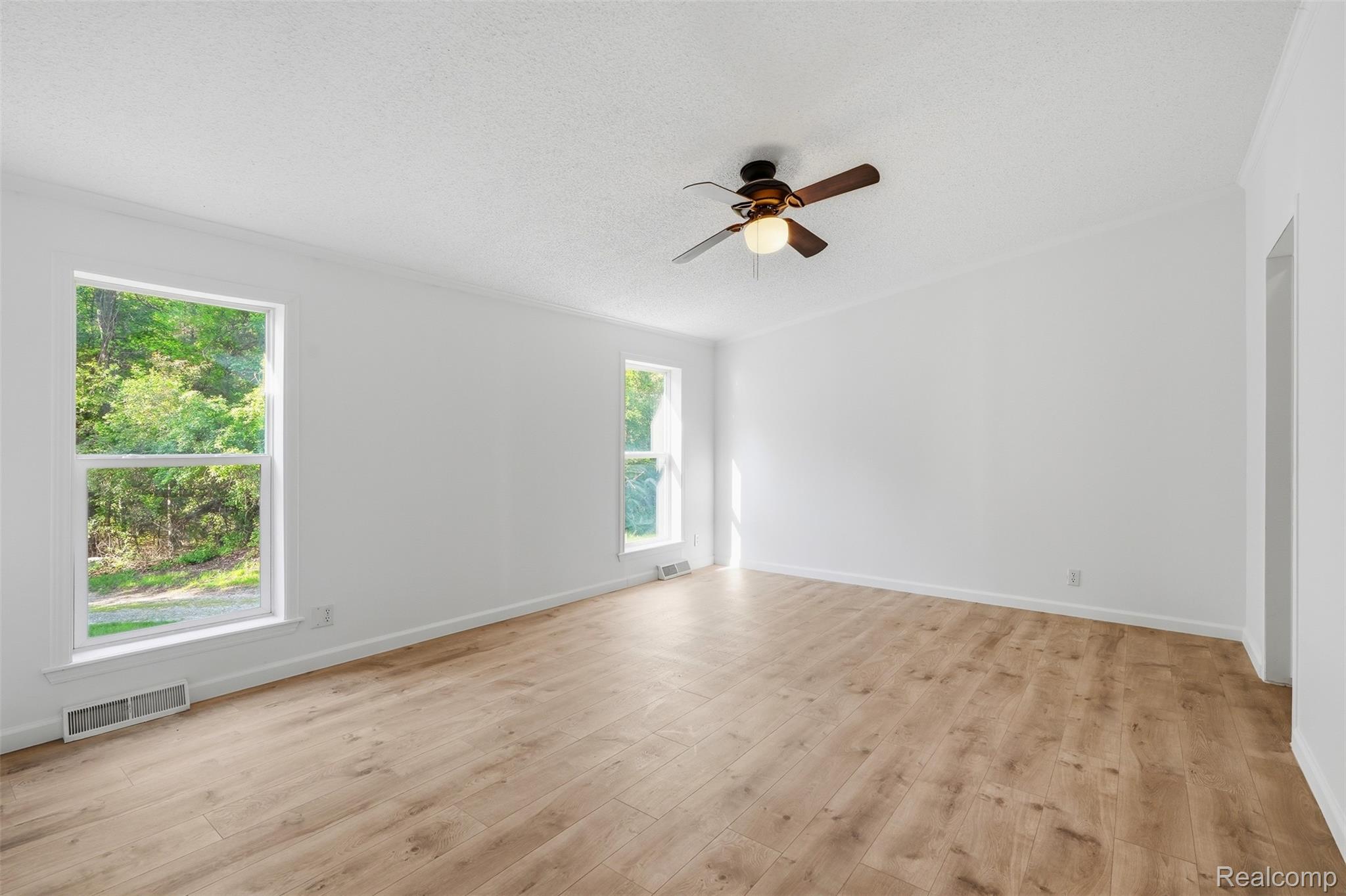 3432 Stanton Road Oxford, MI 48371 - Photo 19 of 48 Spacious room featuring wood-finish flooring, white walls, and a ceiling fan with integrated lighting