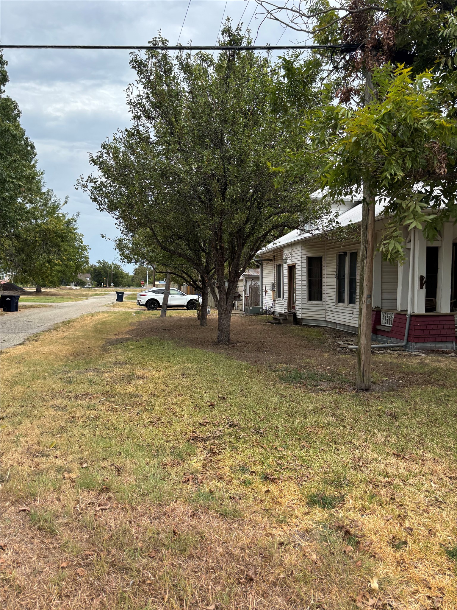 201 South Rio Grande Street Granger, TX 76530 - Photo 12 of 12 Mature trees shade the grassy yard alongside this classic wood-sided home.