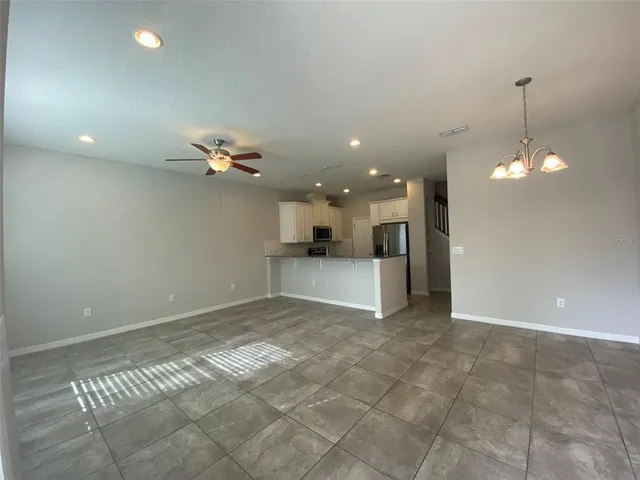 a view of a livingroom and a kitchen space with a chandelier