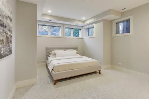 a bedroom with a large bed and a chandelier