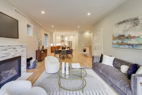 a living room with furniture a flat screen tv and a fireplace