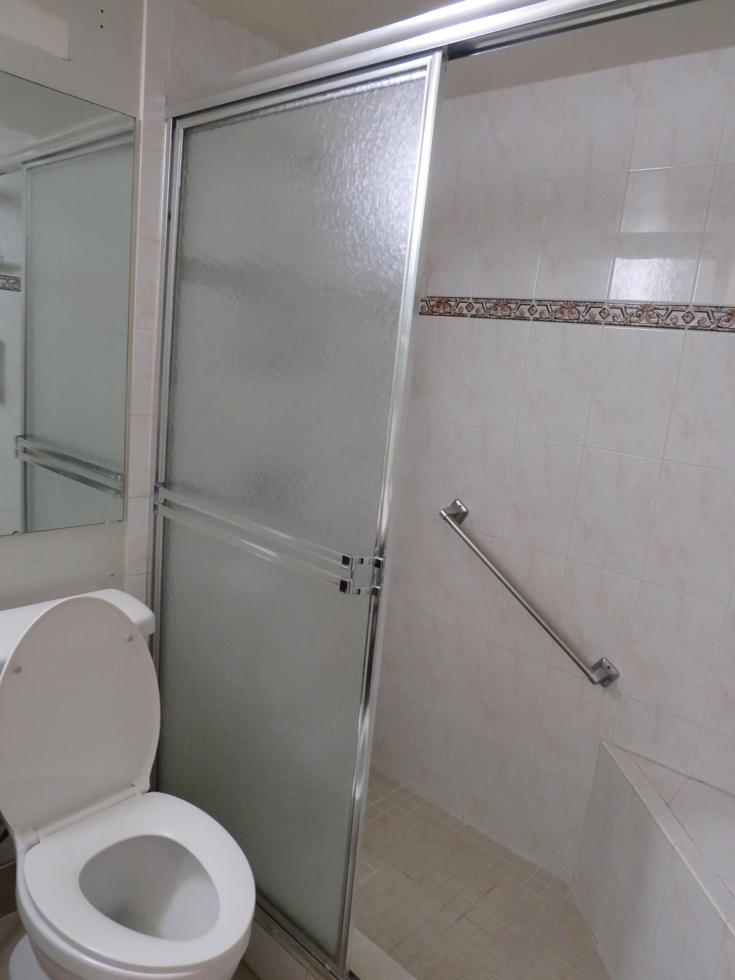 335 Pine Ridge Circle, Unit D1 Greenacres, FL 33463 - Photo 23 of 30 a white toilet sitting next to a shower