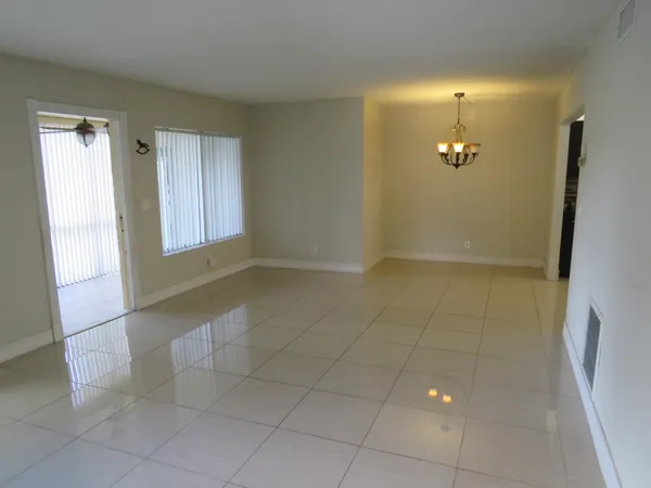 an empty room with kitchen view