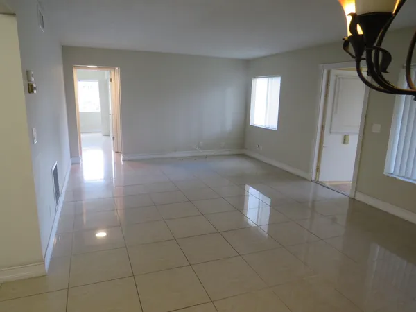 a view of an empty room with a bathroom and a window