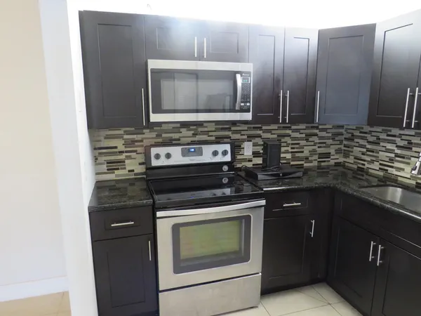 a kitchen with stainless steel appliances a stove microwave and sink