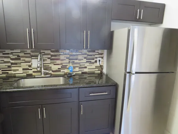 a kitchen with stainless steel appliances granite countertop a refrigerator and a sink