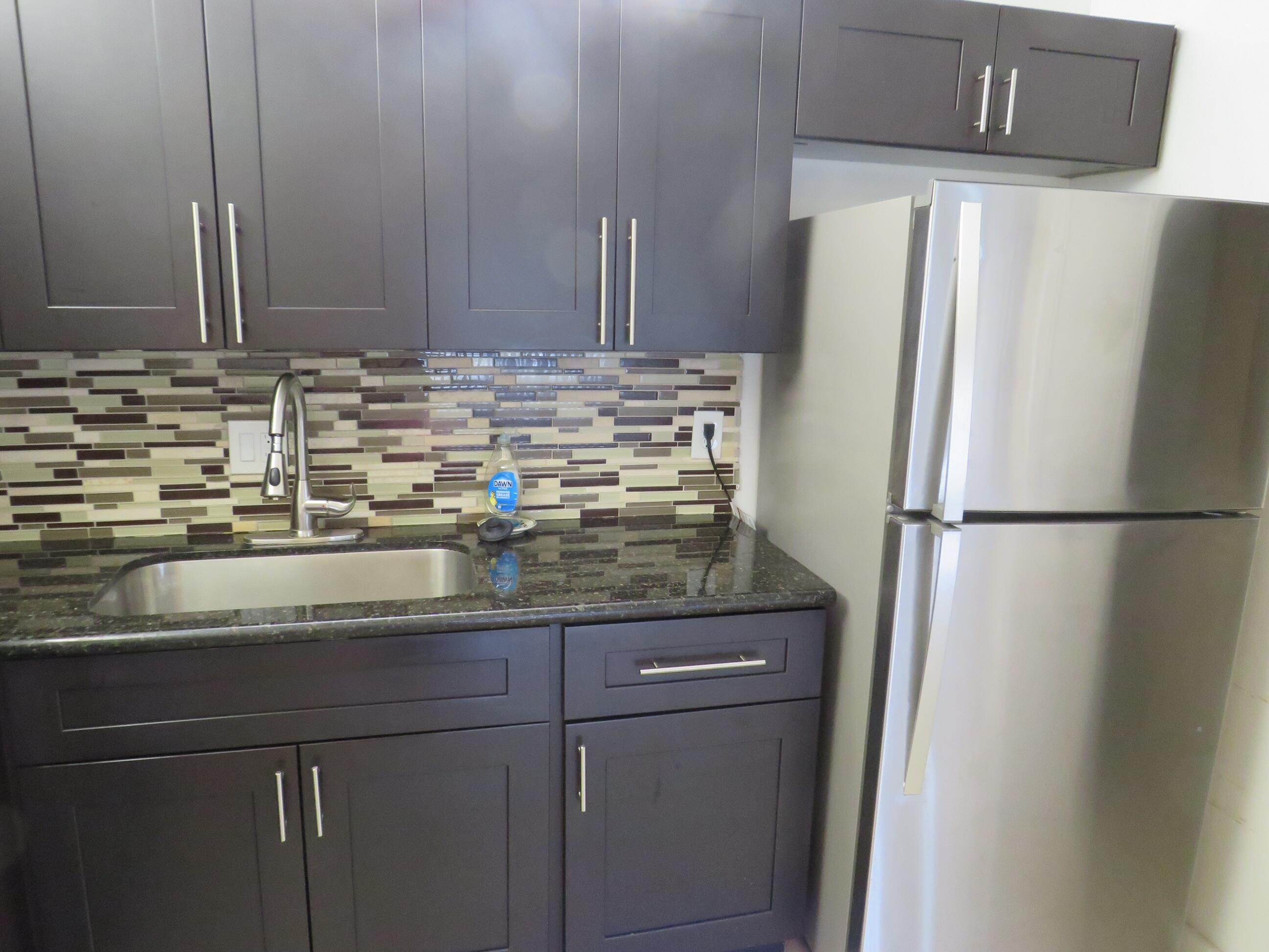 335 Pine Ridge Circle, Unit D1 Greenacres, FL 33463 - Photo 8 of 30 a kitchen with stainless steel appliances granite countertop a refrigerator and a sink