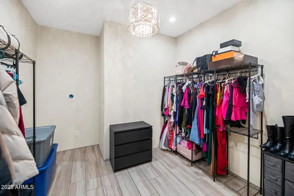 a view of walk in closet with clothes and shoes