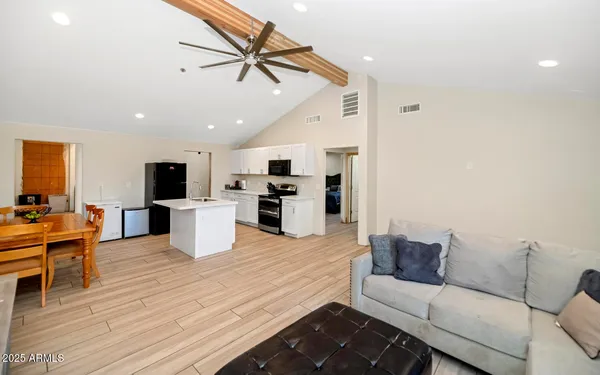 a living room with furniture kitchen view and a refrigerator