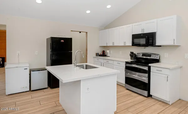 a kitchen with stainless steel appliances white cabinets and wooden floor