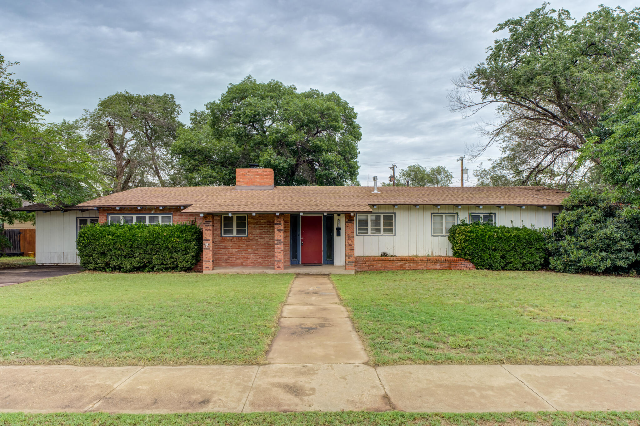a front view of a house with yard and green space