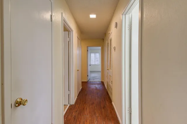 a view of a hallway with wooden floor