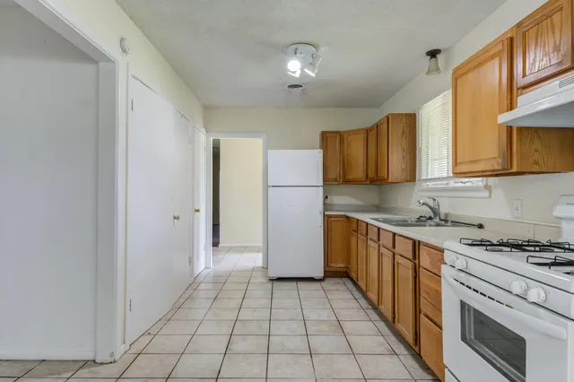 a kitchen with stainless steel appliances granite countertop a refrigerator and a stove top oven
