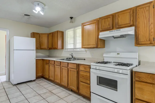 a kitchen with a sink a stove and cabinets