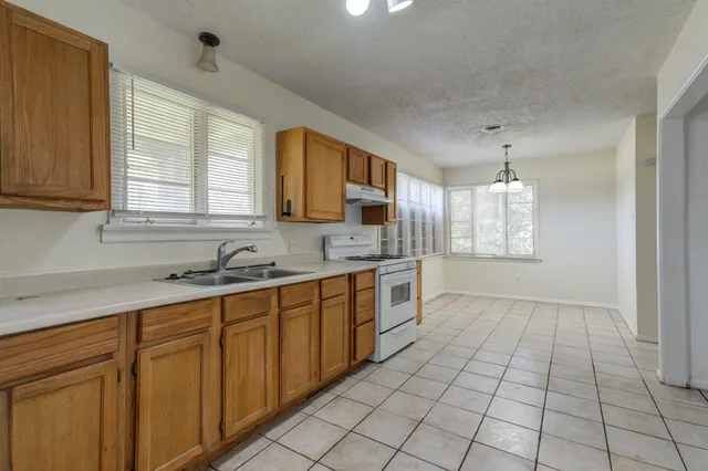 a kitchen with stainless steel appliances a sink stove and cabinets