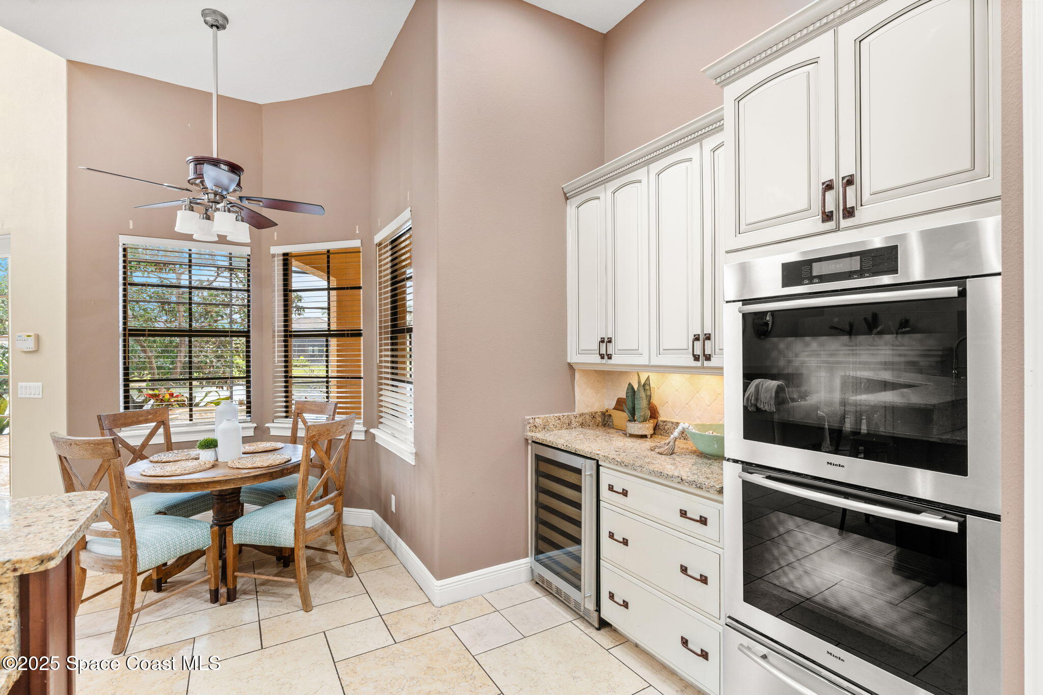 6205 Anello Drive Melbourne, FL 32940 - Photo 14 of 49 a kitchen with stainless steel appliances white cabinets and a stove top oven