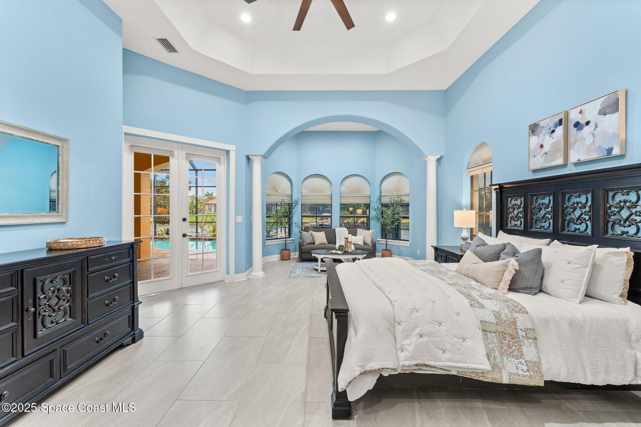 6205 Anello Drive Melbourne, FL 32940 - Photo 16 of 49 a large bedroom with a bed and glass windows