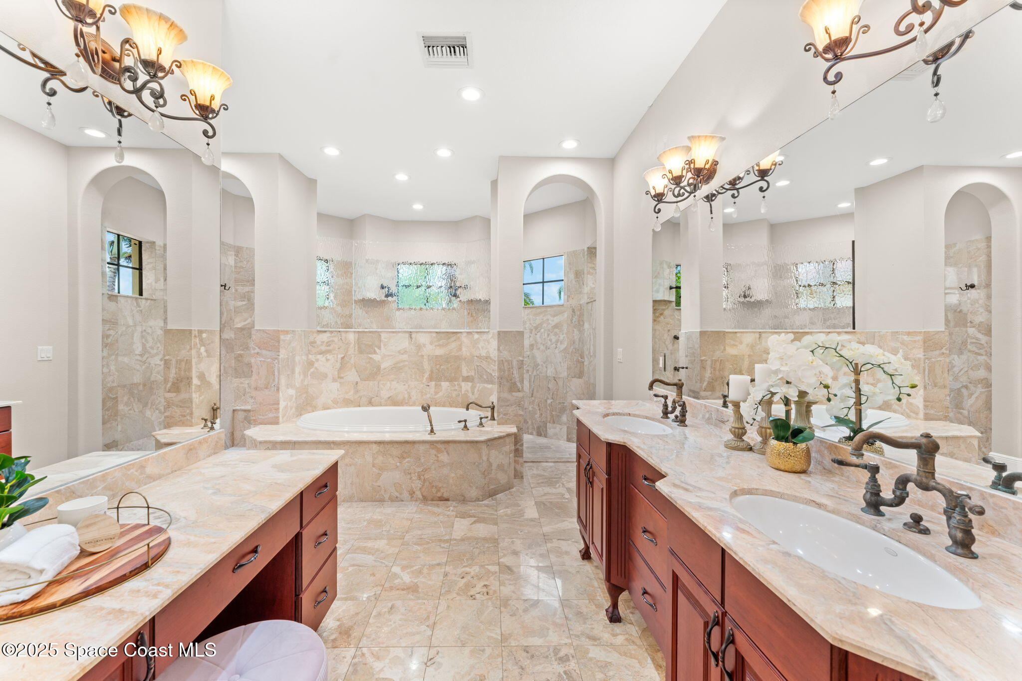 6205 Anello Drive Melbourne, FL 32940 - Photo 18 of 49 a spacious bathroom with a granite countertop tub a double vanity sink a mirror and a shower
