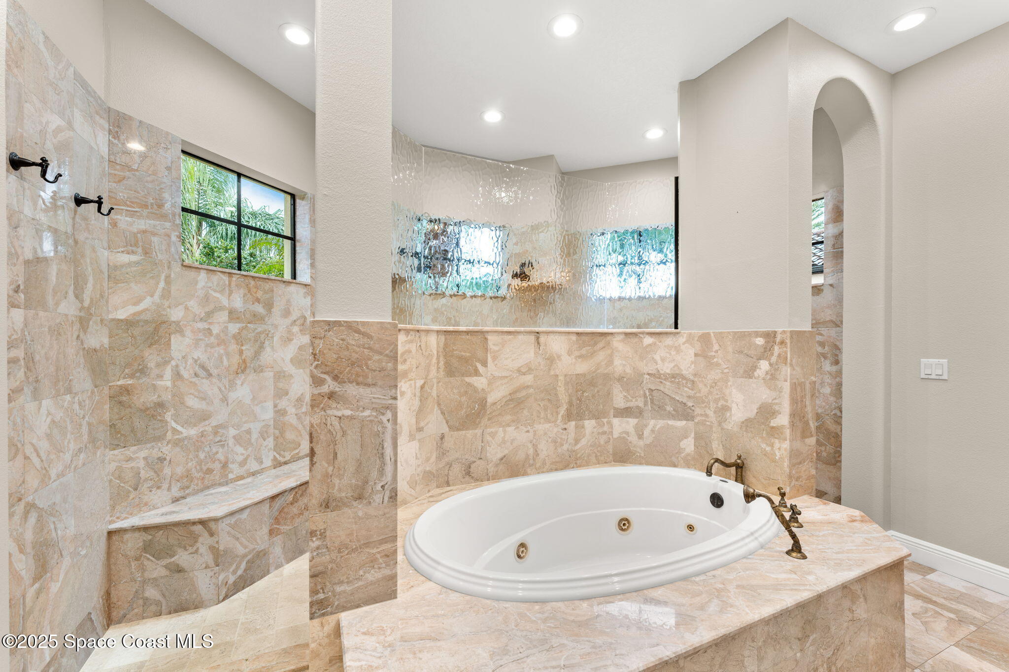 6205 Anello Drive Melbourne, FL 32940 - Photo 19 of 49 a bathroom with a tub sink and mirror