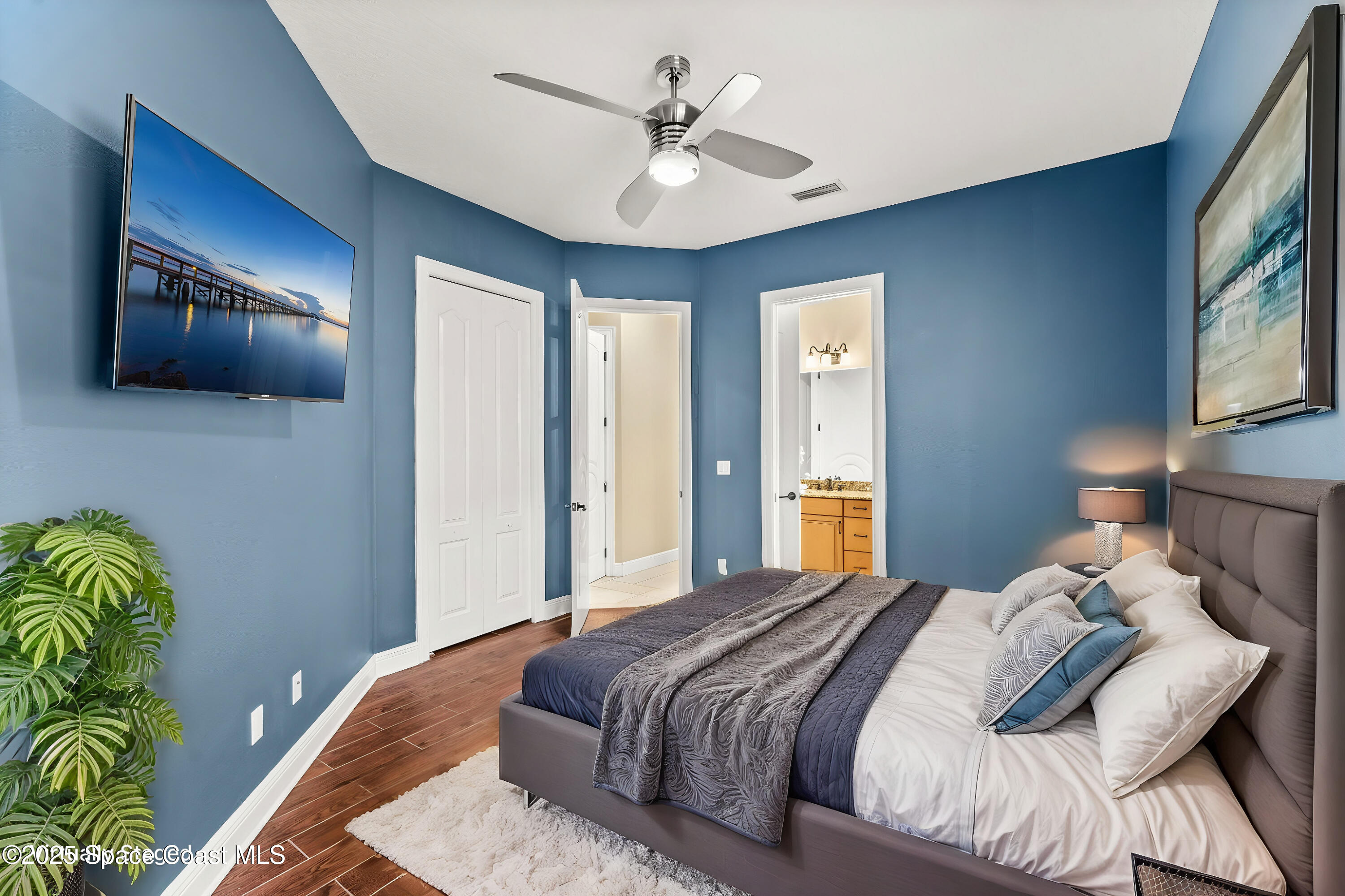 6205 Anello Drive Melbourne, FL 32940 - Photo 22 of 49 a bedroom with a bed and a chandelier