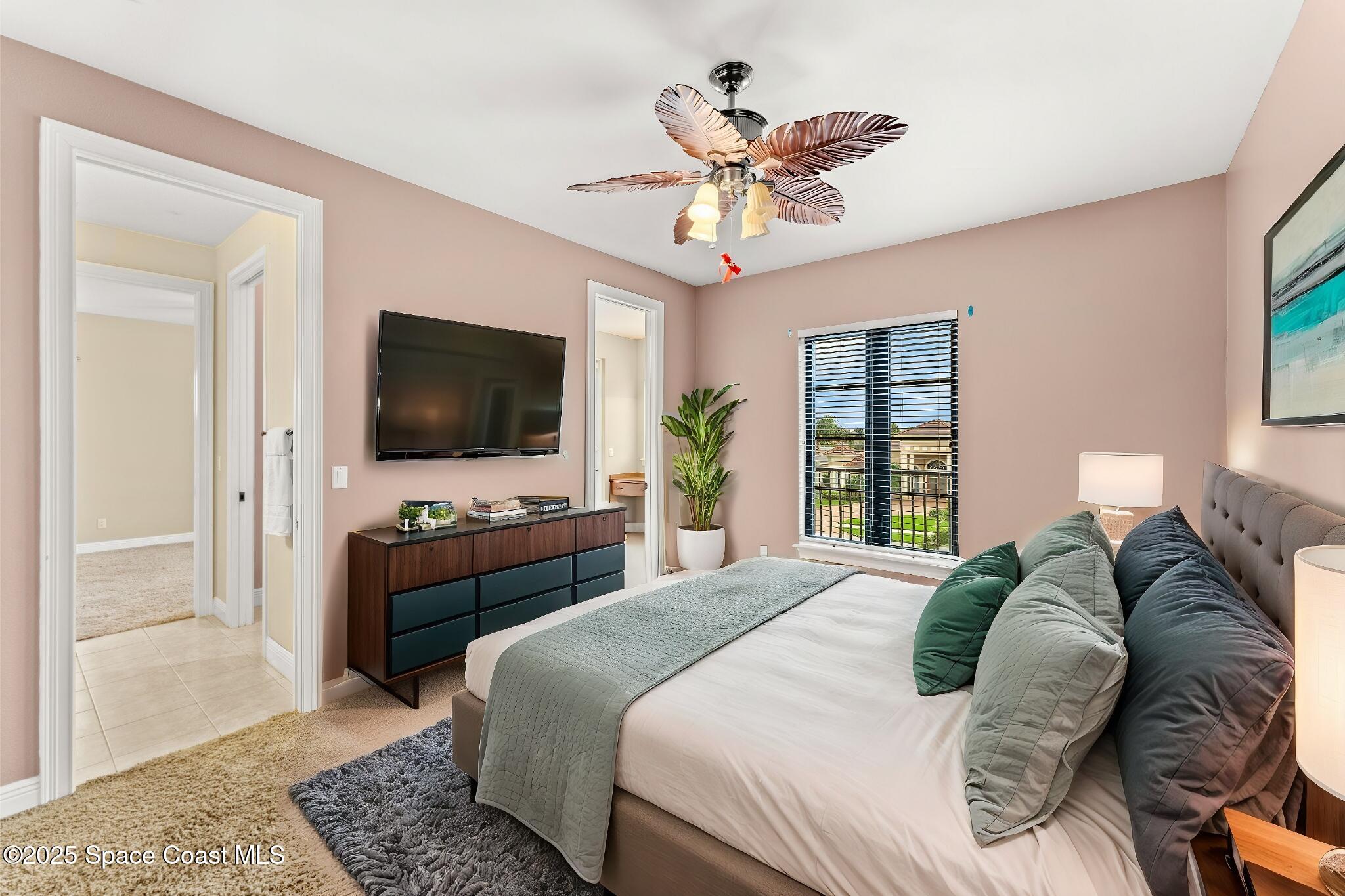 6205 Anello Drive Melbourne, FL 32940 - Photo 30 of 49 a bedroom with a bed and a flat screen tv