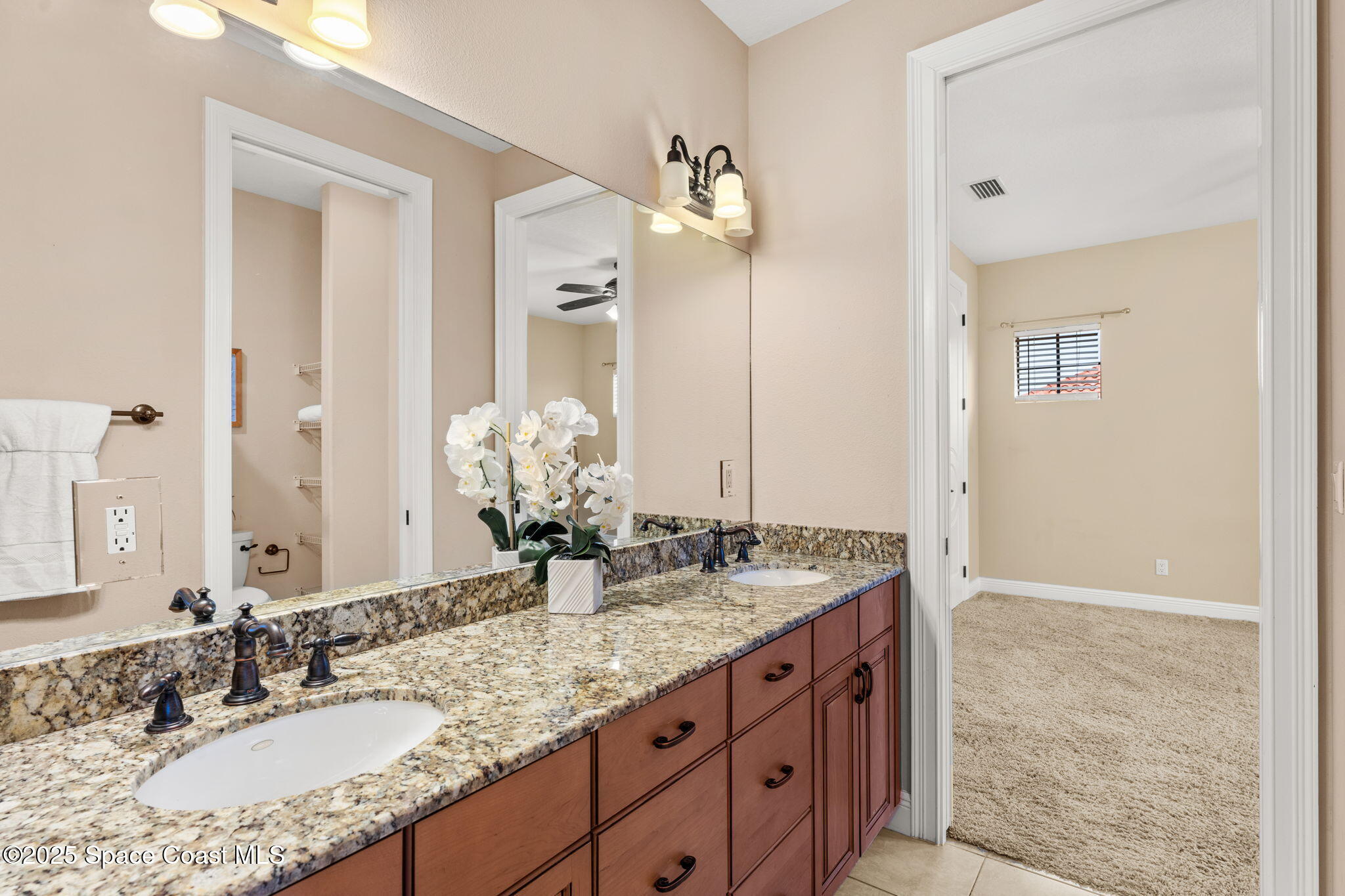6205 Anello Drive Melbourne, FL 32940 - Photo 31 of 49 a bathroom with a granite countertop double vanity sink and a mirror