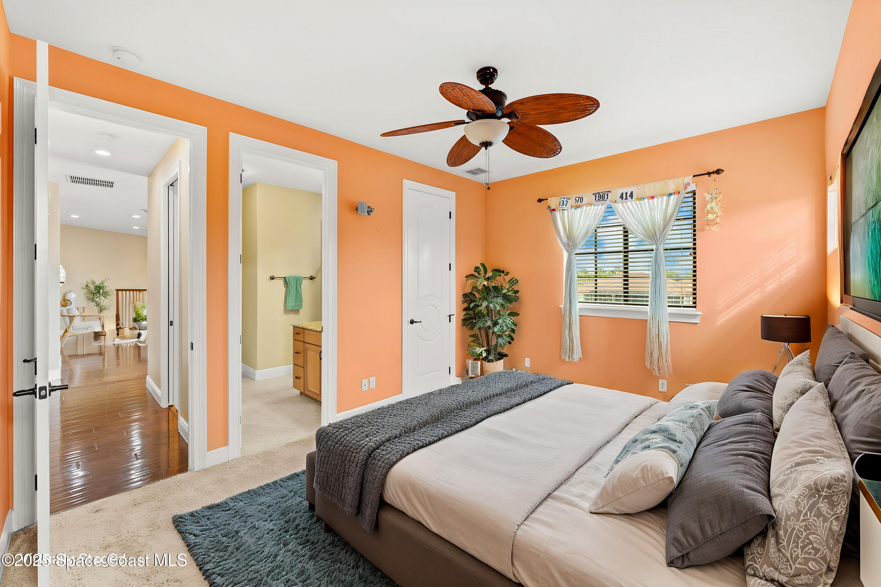 6205 Anello Drive Melbourne, FL 32940 - Photo 35 of 49 a bedroom with a large bed and a chandelier