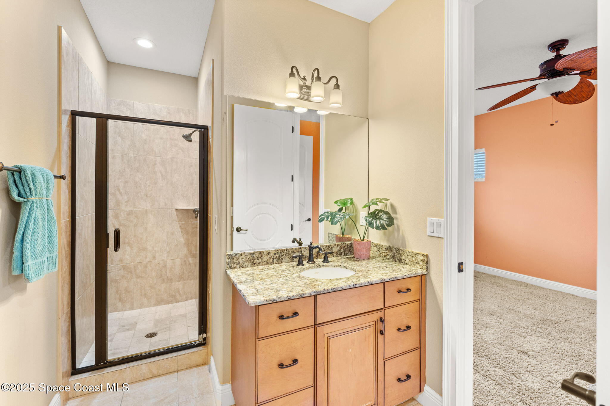 6205 Anello Drive Melbourne, FL 32940 - Photo 36 of 49 a bathroom with a granite countertop shower sink vanity and mirror