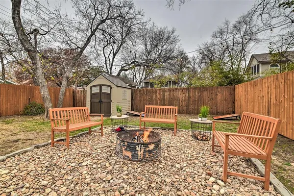 a view of a chairs and table in backyard