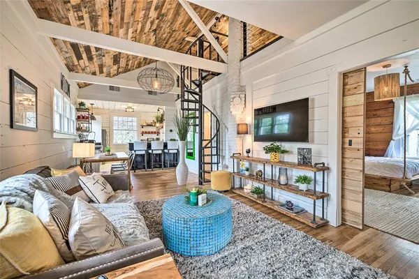 a living room with furniture a flat screen tv and a floor to ceiling window