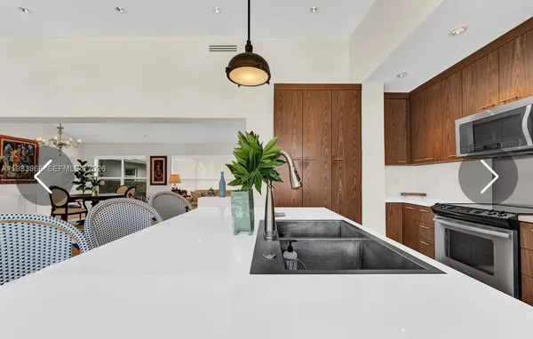 a kitchen with stainless steel appliances a counter space a sink and cabinets