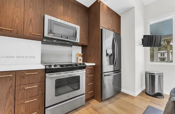 a kitchen with stainless steel appliances granite countertop a refrigerator stove and wooden cabinets