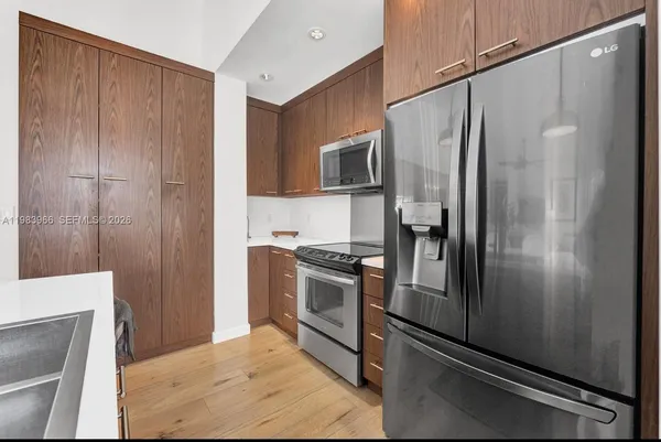 a metallic refrigerator freezer sitting inside of a kitchen