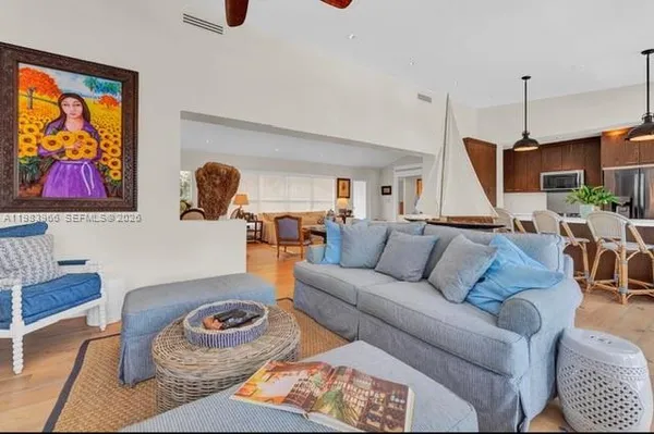 a living room with furniture kitchen view and a window