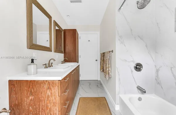 a bathroom with a tub sink and mirror