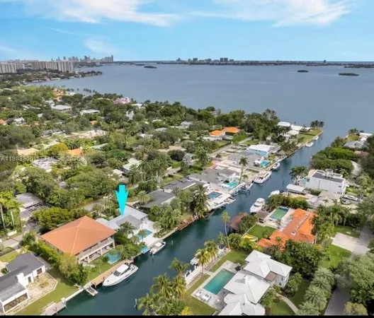 an aerial view of ocean and residential houses with outdoor space