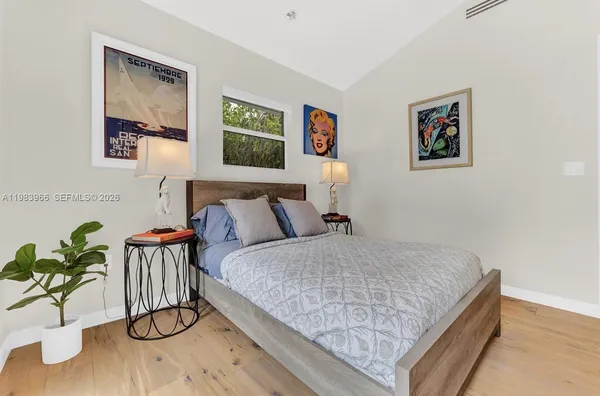 a bedroom with bed and painting on the wall