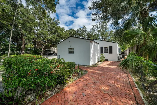 a backyard of a house with a garden and outdoor seating