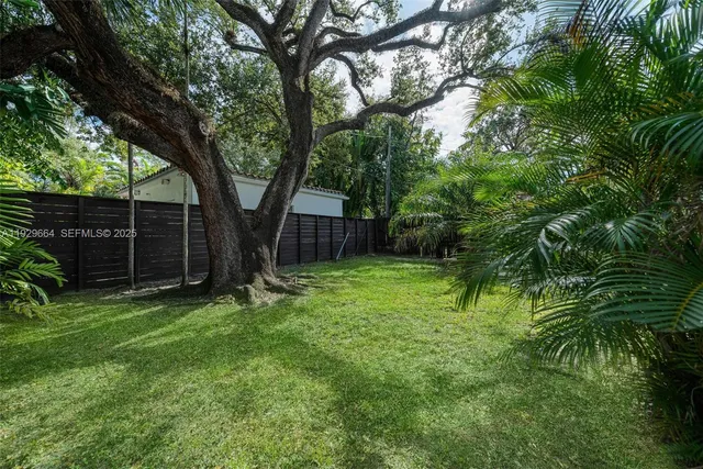 a view of a backyard with large trees
