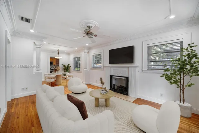 a living room with furniture a fireplace and a potted plant