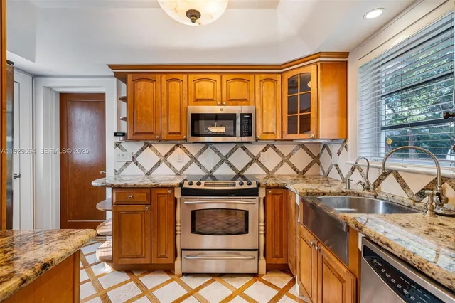 a kitchen with stainless steel appliances granite countertop a stove a sink and a microwave