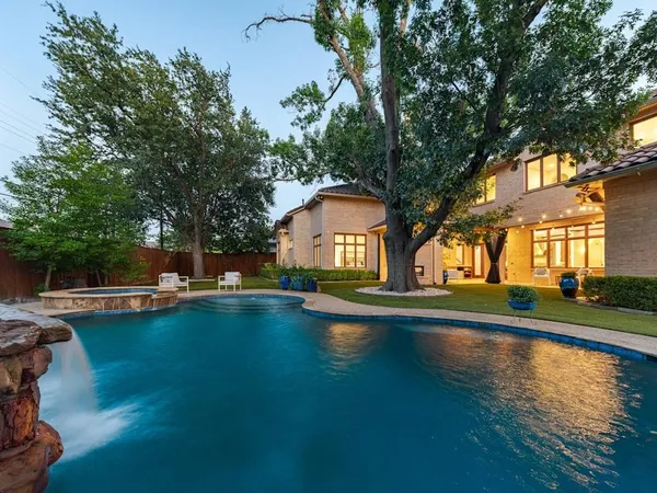 a view of pool with umbrella and trees