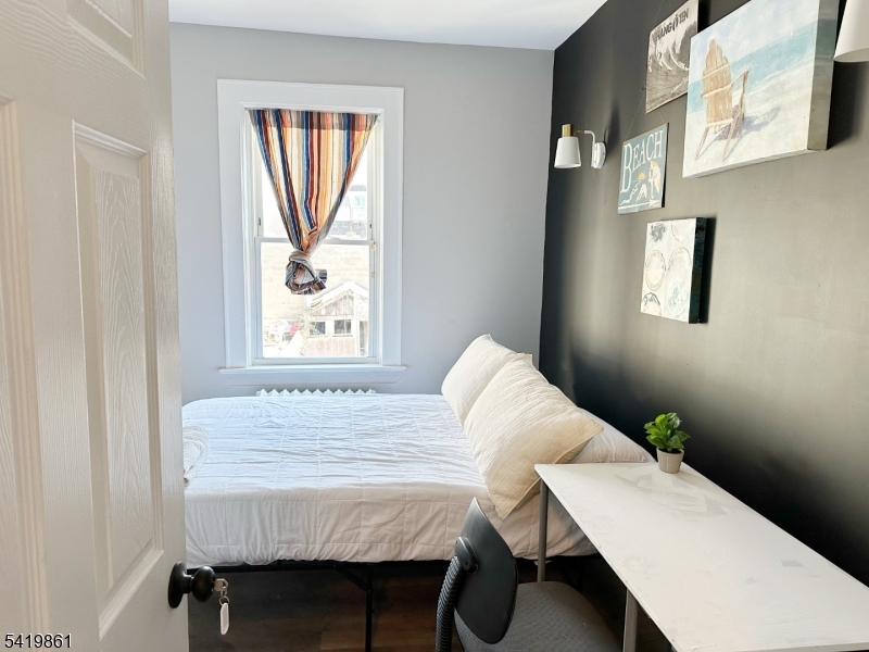 34 Duryea Street Newark, NJ 07103 - Photo 11 of 15 a bed sitting in a bedroom next to a window