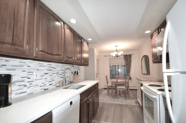 a kitchen with stainless steel appliances a sink stove and cabinets