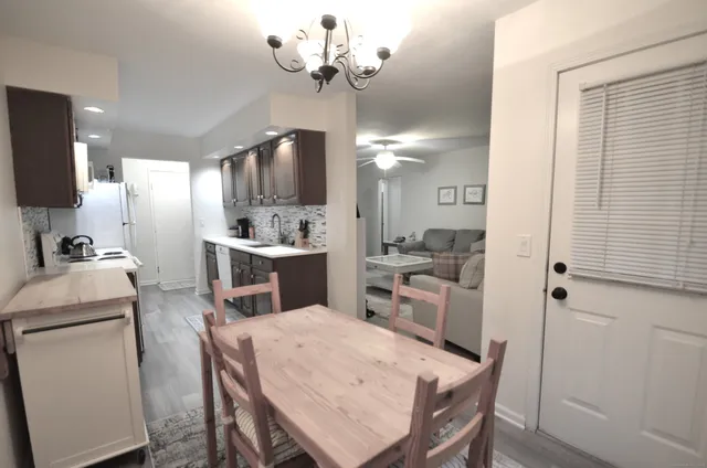 a kitchen that has a table chairs and a refrigerator