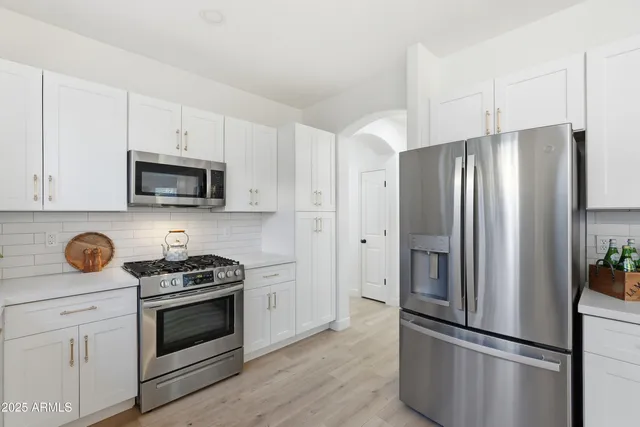 a kitchen with stainless steel appliances a refrigerator sink and cabinets